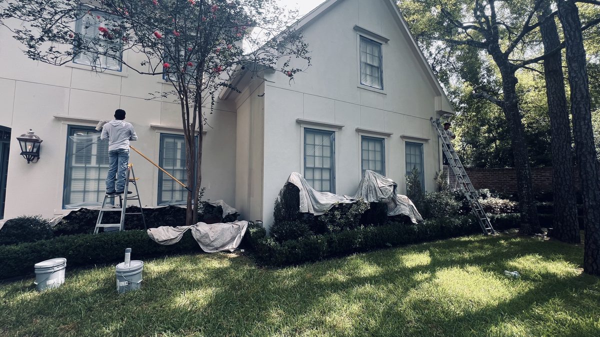 Crew painting a shaded traditional home